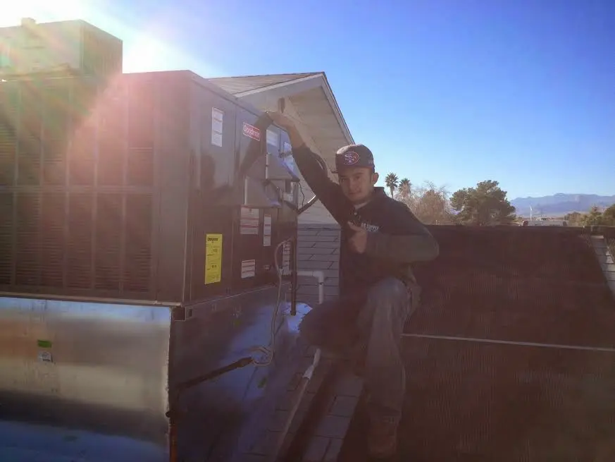 HVAC technician performing Heat Pump Repair on a rooftop unit in Panthersville