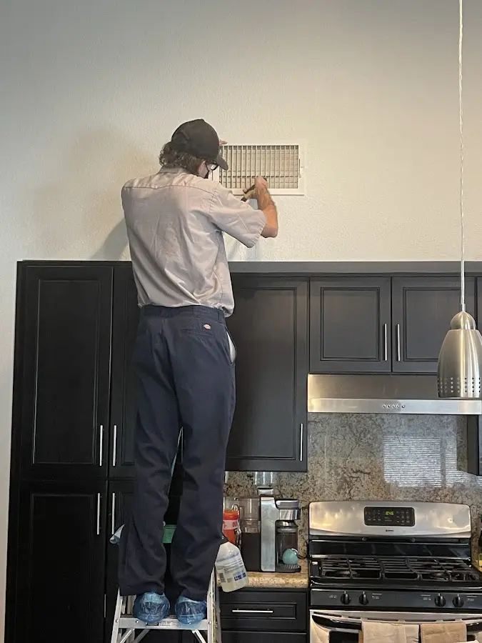 Technician inspecting an air vent during HVAC service in Panthersville